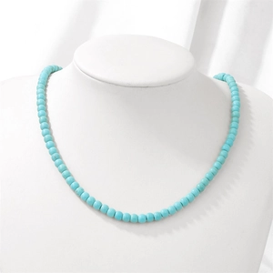 Detail view of a 4mm turquoise bead necklace displayed on a white professional jewelry bust
