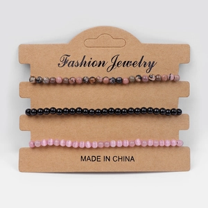 Detailed view of three-piece beaded bracelets on a natural kraft card display