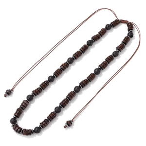 Detail of beaded necklace featuring dark wood discs and black lava stones with adjustable cord
