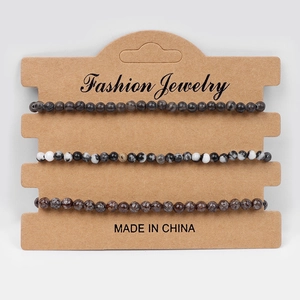Three-piece beaded bracelet set with black, agate, and brown stone textures on a display card