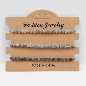 Detail view of 3-piece natural stone bead bracelets set on a brown jewelry display card