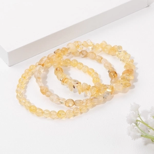 Close-up of yellow crystal bead bracelet set featuring round and irregular stone shapes