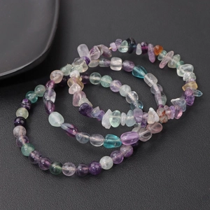 Detailed view of three natural fluorite bracelets with round and irregular beads in purple