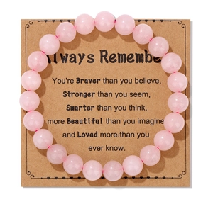 Detailed view of an 8mm pink natural stone bracelet on an inspirational paper gift card