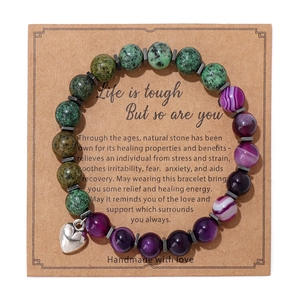Detalle de pulsera de piedras de 8mm con corazón en tarjeta de papel kraft café