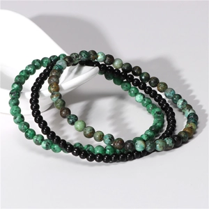 Detailed macro shot of 4mm natural amethyst and green spotted stone beaded stretch bracelets