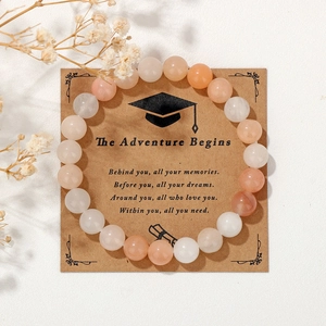 Detail of 8mm natural stone beaded bracelet on graduation gift card with dried flowers