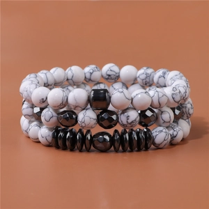 Makro-Detail von dreiteiligen Natursteinperlen-Armbändern mit schwarzen Hämatit-Akzenten