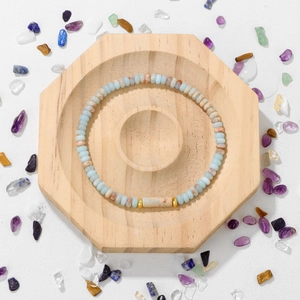 Detalle de cuentas de piedra azul emperador con espaciadores dorados en pulsera elástica