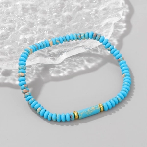 Detalle de pulsera de piedras imperiales azules con espaciadores dorados y cuenta cilíndrica