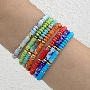 Set de seis pulseras elásticas de cuentas coloridas con espaciadores dorados en la muñeca