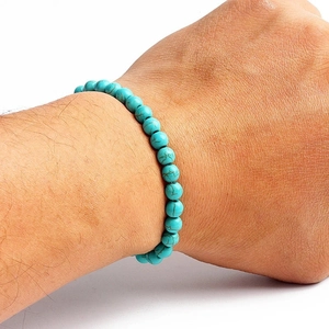 Detailed close-up of natural turquoise bead bracelet with brown veins on a wrist