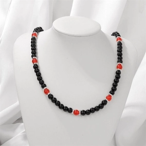Elegant beaded necklace featuring black onyx and red agate beads on a white satin stand