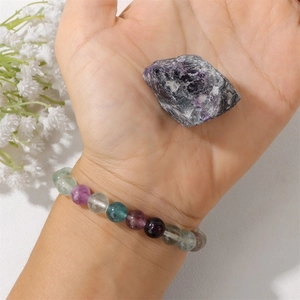 Primer plano de pulsera de cuentas de fluorita natural con una piedra preciosa morada