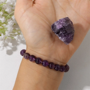 Pulsera de cuentas de amatista natural de 8mm con piedra de cristal cruda en mano fondo blanco