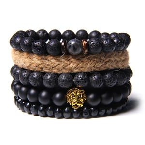 Detailansicht eines mehrlagigen Perlenarmbands mit goldenem Löwenkopf und Natursteinen