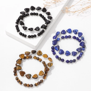 Makro-Detail von Naturstein-Armbändern mit Tigerauge und Herz-Anhängern im Set