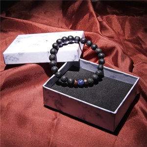 Bracciale di perle laviche con perla blu in una confezione regalo in marmo