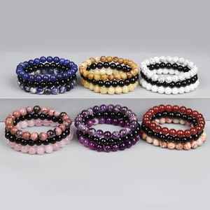 Detailansicht von sechs 8mm Naturstein-Perlenarmband-Sets auf grauem Display