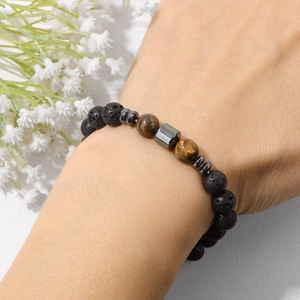 Detalle de pulsera de cuentas de ojo de tigre y lava de 8mm en muñeca con flores