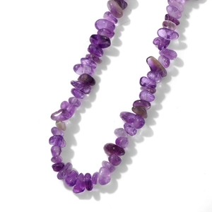 Macro view of irregular natural purple amethyst crystal stone beads on a polished necklace