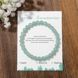 Detail of 8mm Green Aventurine crystal bead stretch bracelet on decorative card packaging