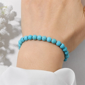 Detail shot of 6mm turquoise style beaded bracelet with natural mineral textures on wrist