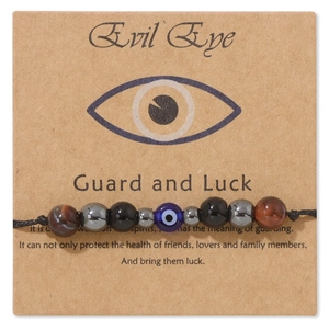 Dettaglio macro del bracciale Evil Eye con perle in Occhio di Tigre ed Ematite su carta