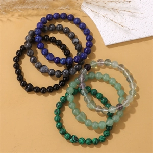 Makroaufnahme von Naturstein-Armbändern mit Herzanhängern auf gelbem Hintergrund
