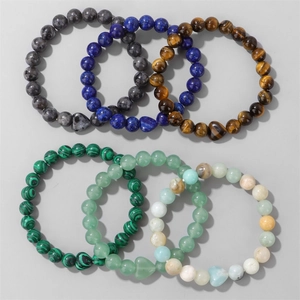 Nahaufnahme von 6 Naturstein-Armbändern mit Tigerauge und Malachit-Herzanhängern