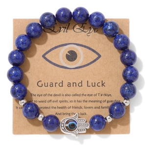 Détail du bracelet Hamsa en perles bleues avec œil maléfique sur carte kraft