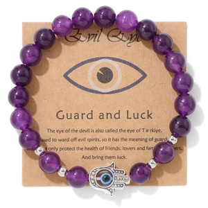Détail du bracelet en perles violettes avec main de Fatma argentée et œil protecteur