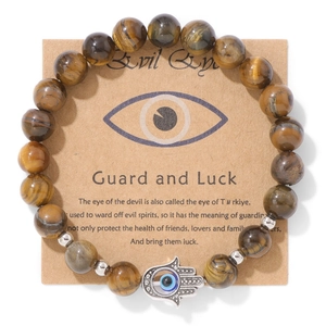 Détail du bracelet en œil de tigre avec breloque main de Hamsa sur carte présentoir
