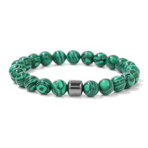 Primer plano de cuentas de malaquita verde con acento cilíndrico de metal pulido en pulsera