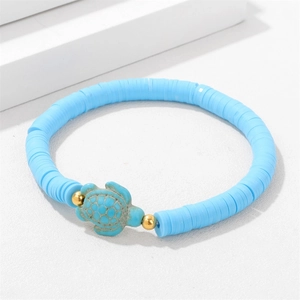 Detail of sky blue heishi beads bracelet with a turquoise turtle pendant and gold accents