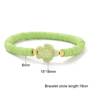 Detailed view of 6mm green Heishi beads and 15x18mm turtle charm on an elastic bracelet