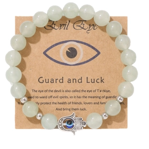 Bracelet en perles vertes avec main de Fatma argentée et œil bleu sur carte de support