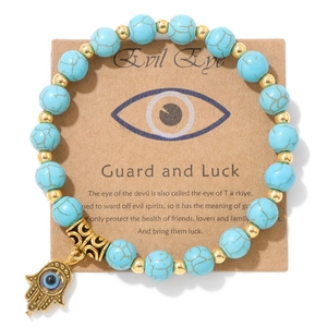 Détail du bracelet main de Fatma et œil maléfique sur carte avec perles turquoise