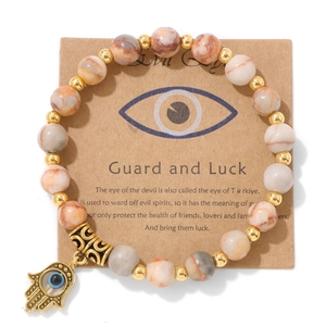 Vue détaillée du charme Main de Fatima et Œil de Turquie sur bracelet en pierre