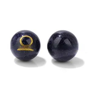Macro shot of 10mm blue sandstone beads with golden Libra and Sagittarius zodiac symbols
