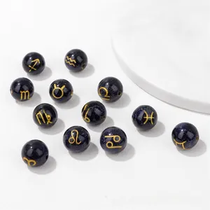 Macro shot of 10mm blue sandstone beads with golden zodiac signs for DIY jewelry