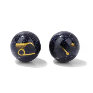 Macro shot of 10mm blue sand beads with gold Cancer and Leo zodiac signs for DIY jewelry
