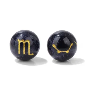 Macro shot of 10mm Scorpio blue sandstone beads with gold zodiac signs and star maps