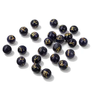 Detailed view of 10mm blue sandstone beads with golden zodiac signs for DIY jewelry