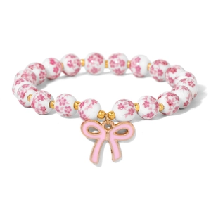 Close-up of white ceramic beads with pink floral patterns and a cute bow pendant