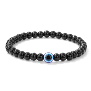 Makro-Detail der 6mm schwarzen polierten Steinperlen mit blauem Evil Eye Anhänger am Armband