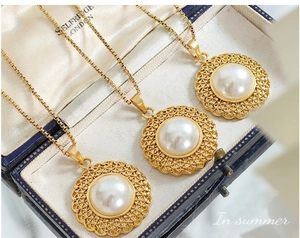 Close-up of golden pearl necklaces in vintage blue box with fine hollow lace detail