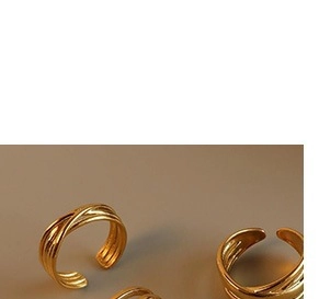 Macro detail of gold-plated twisted layered open rings with a polished finish
