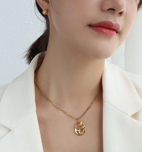 Primer plano del collar con colgante de tulipán dorado y pendientes en el modelo