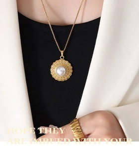 Detail of vintage gold pearl necklace and ribbed ring worn on a stylish female model